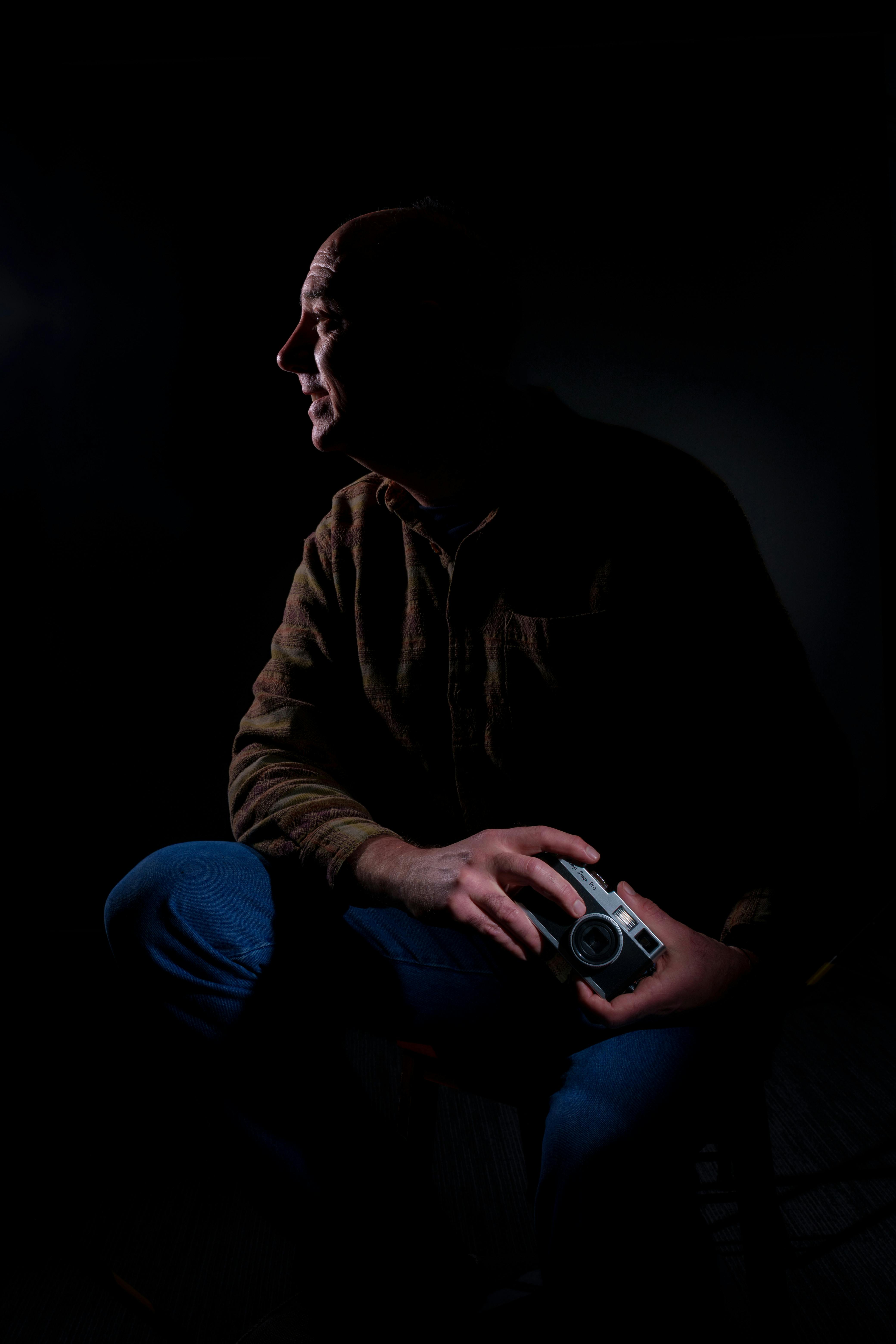 A dramatic silhouette of a man holding an old camera, exuding a classic and artistic vibe.