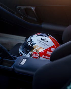 Close-up of a racing helmet on a car seat inside a sports car with sunset lighting.