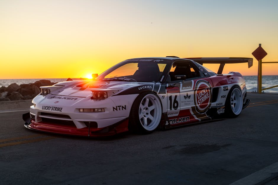 Race car with custom decals on a coastal road during sunset, creating a dynamic scene.