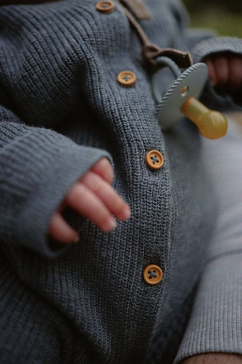 Free Adorable baby wearing a knitted sweater with pacifier, showing warmth and comfort. Stock Photo