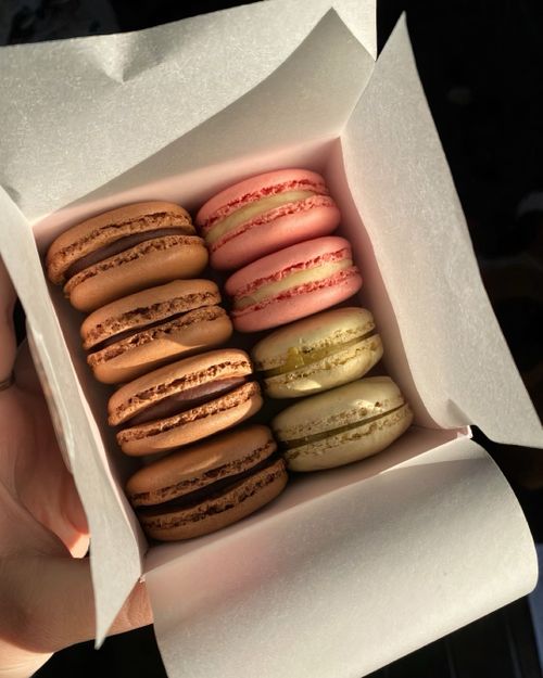 Free A box of assorted macarons in various flavors captured in soft natural light. Stock Photo