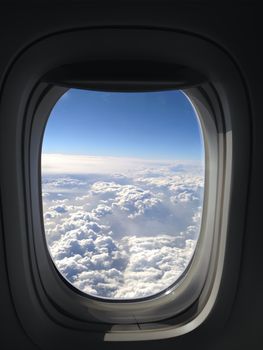 A breathtaking view of clouds and sky through an airplane window during flight.