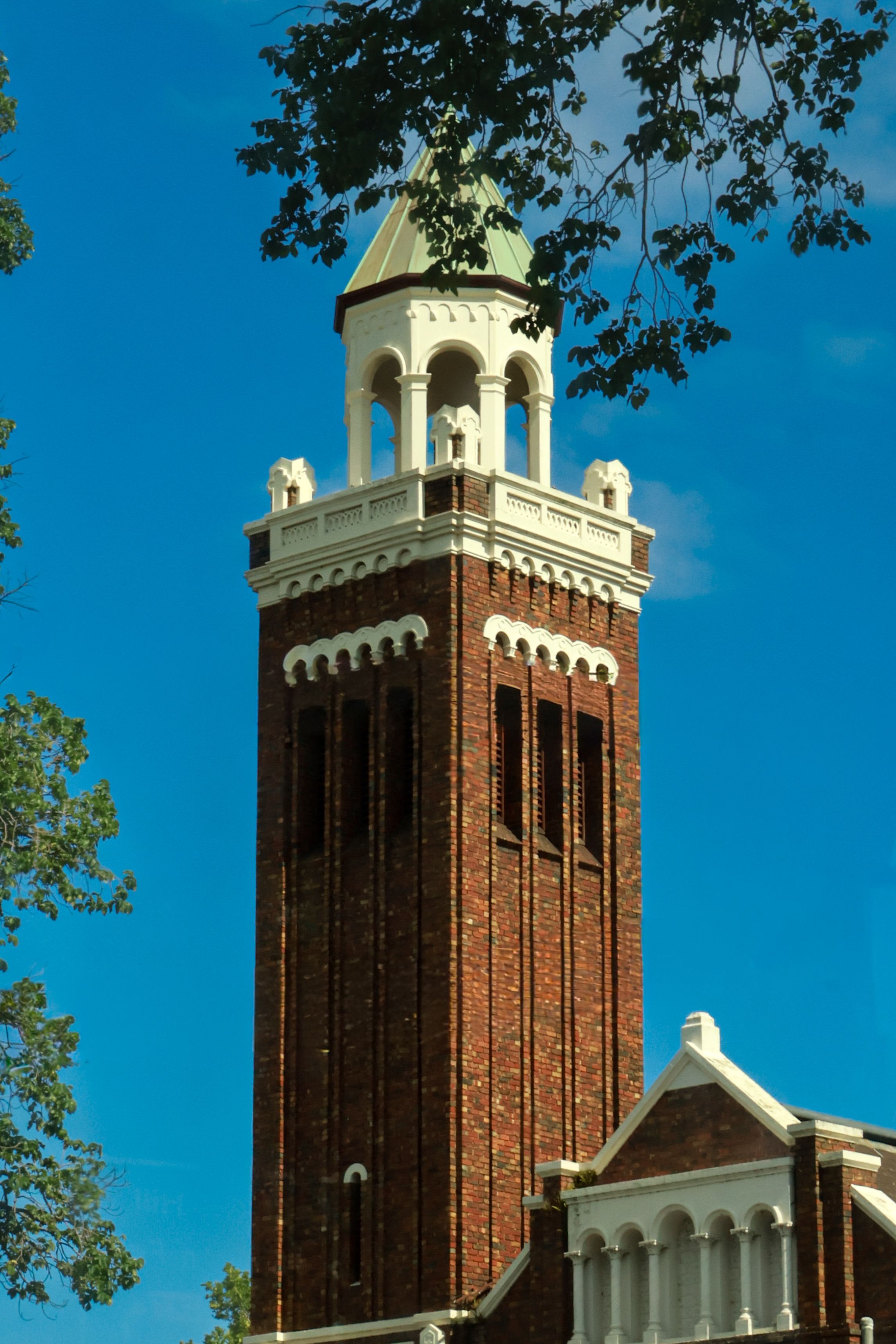 Historic Brick Bell Tower Under Clear Blue Sky · Free Stock Photo