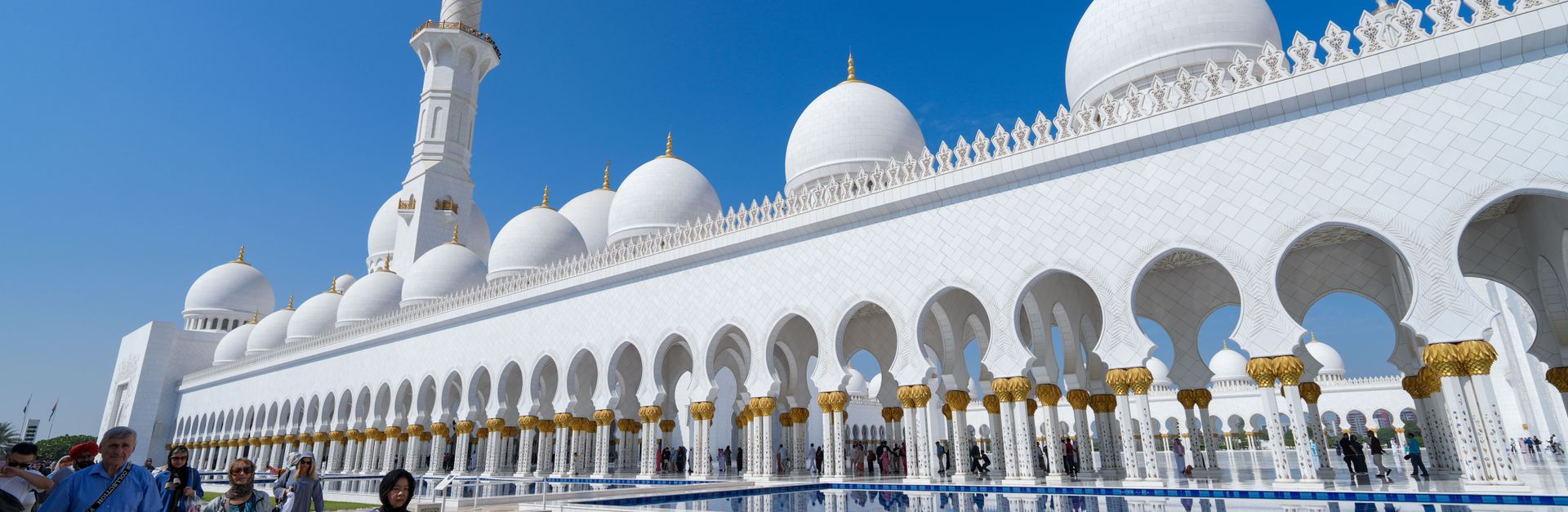 Visitors at Sheikh Zayed Grand Mosque in Abu Dhabi marvel at its stunning white domes and architectu