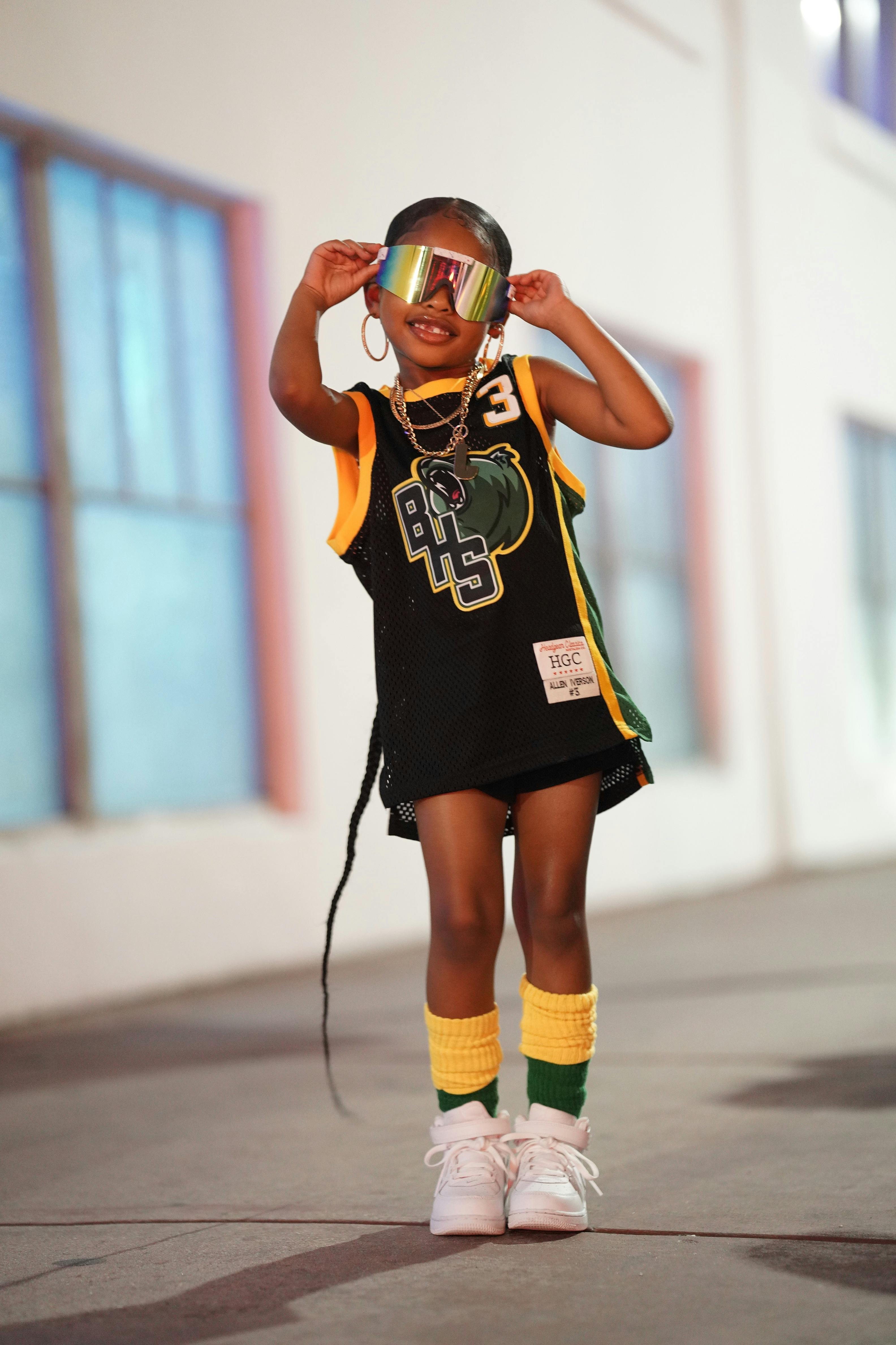 Gratis Un bambino chic indossa un abbigliamento sportivo e occhiali da sole riflettenti nelle vivaci strade di Miami. Foto a disposizione