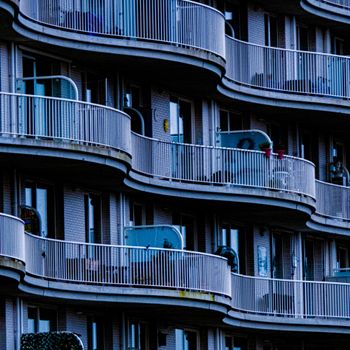 A detailed view of stylish curved balconies in a modern apartment complex.