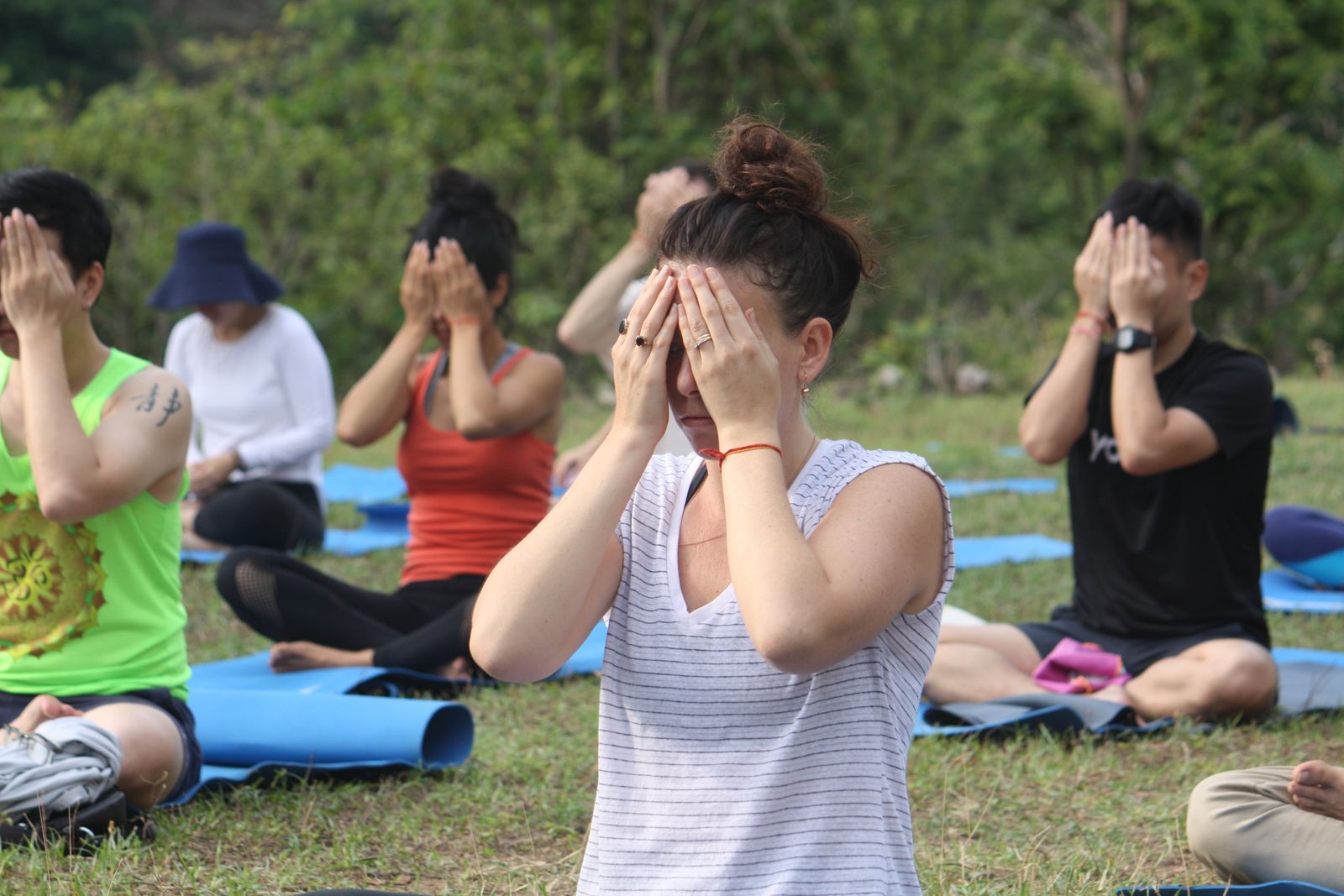 Group of yoga practitioners meditating outdoors at an ashram-style retreat, reflecting the tradition behind satya and Satyananda yoga