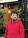 Young Man in Red Hoodie Outside a Café