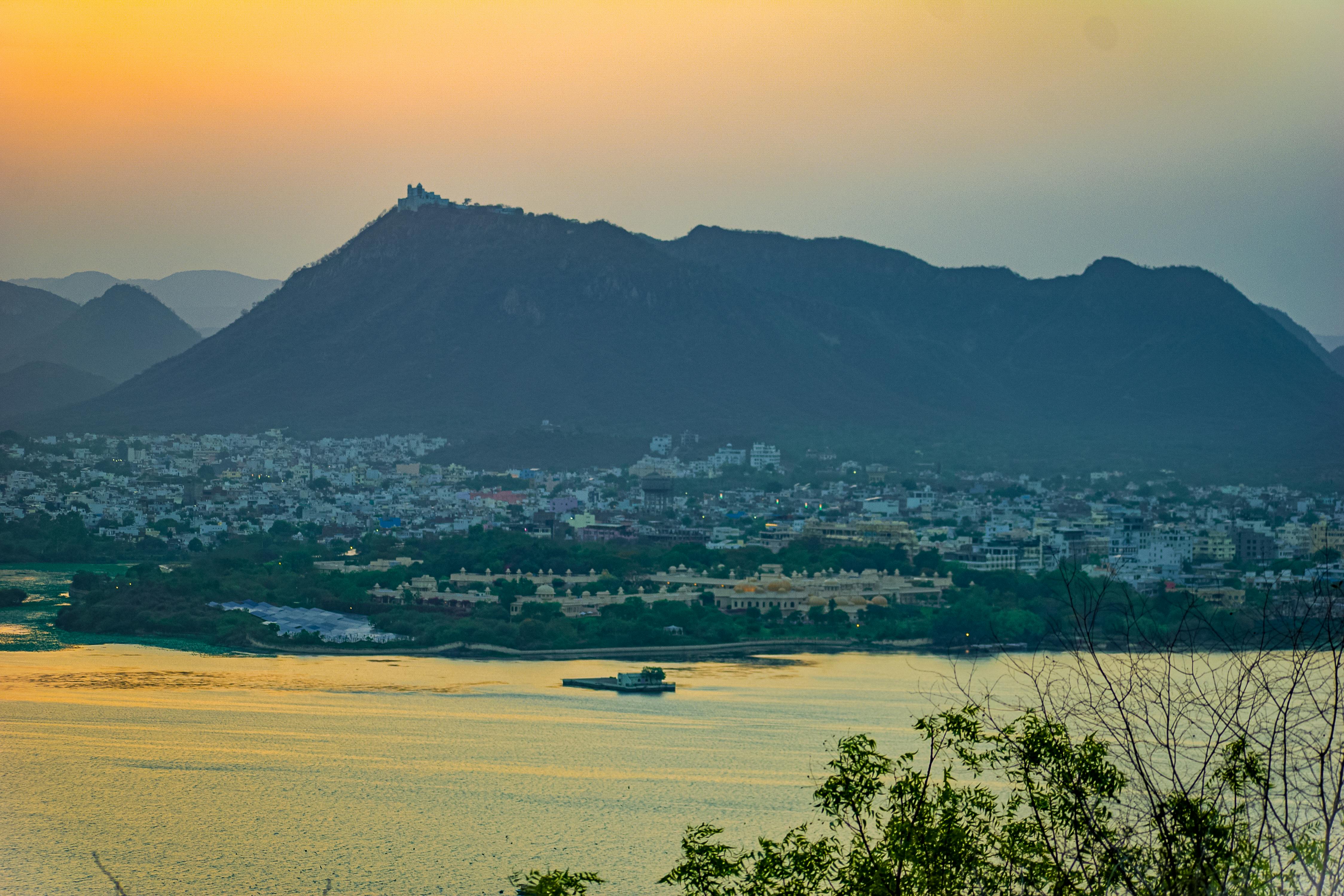 Scenic view of Udaipur city and surrounding hills at sunset