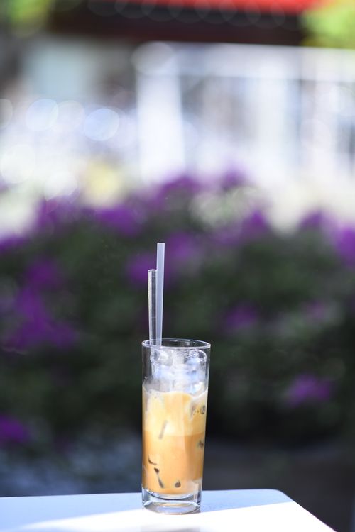 Free A tall glass of iced coffee with a straw on a sunny day, perfect for refreshment. Stock Photo