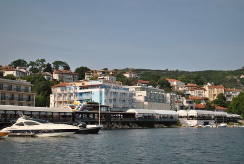 Free Coastal town with colorful buildings overlooking the waterfront and boats, under a clear sky. Stock Photo