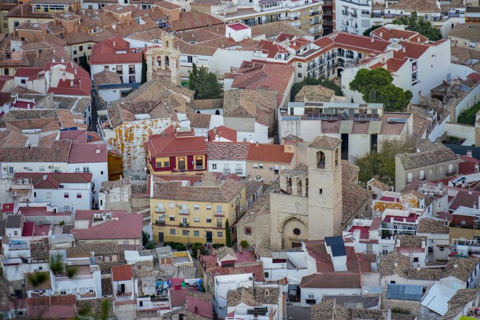 Impresionante toma aérea que muestra la arquitectura histórica de Jaén, Andalucía, con tejados vibrantes y un campanario prominente.