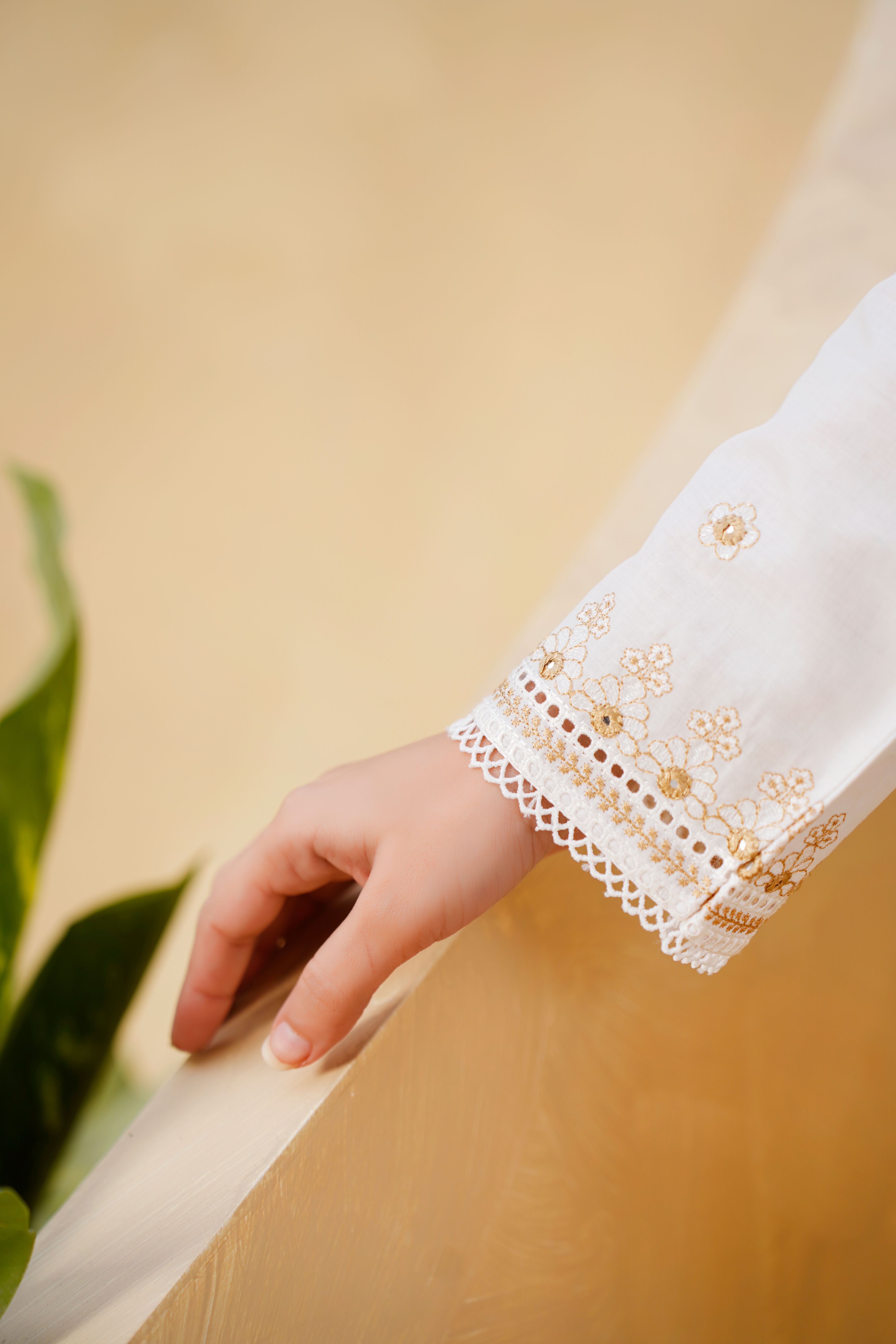 Elegant close-up of an embroidered sleeve featuring delicate floral patterns and textures.