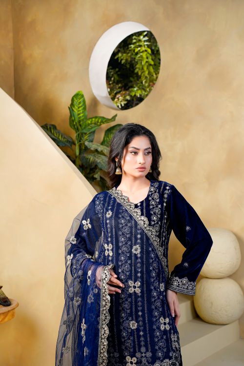 Free Fashion model in a stunning blue velvet dress posing indoors with stylish decor. Stock Photo
