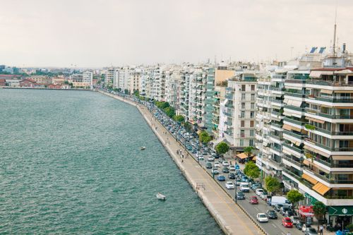 Free Aerial view of a bustling waterfront with high-rise buildings lining the street, showcasing urban life. Stock Photo