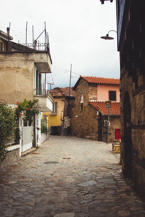 Free Explore a picturesque cobblestone street surrounded by rustic architecture in a historic town. Stock Photo