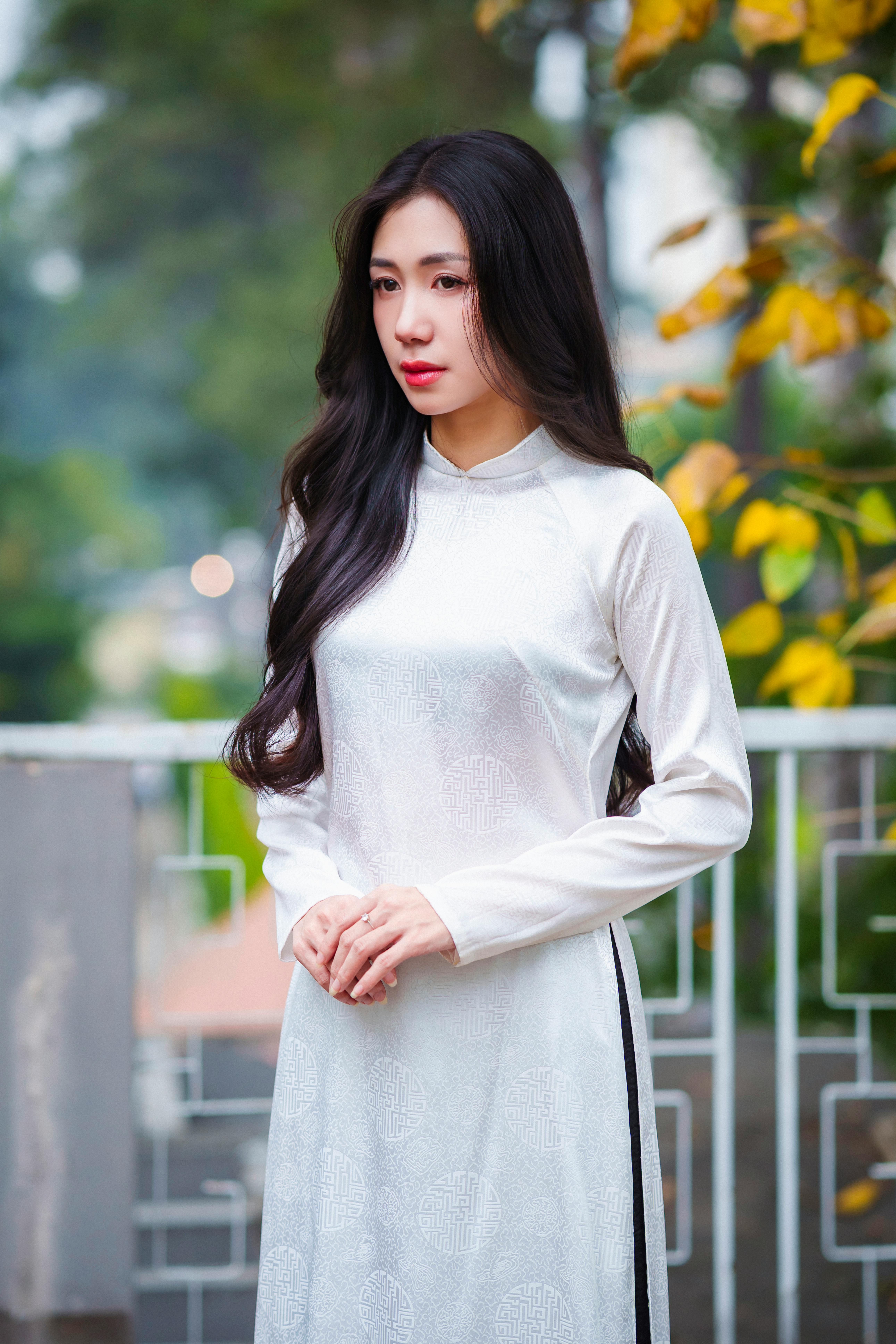 Young woman in white áo dài dress, outdoors in Hồ Chí Minh City.
