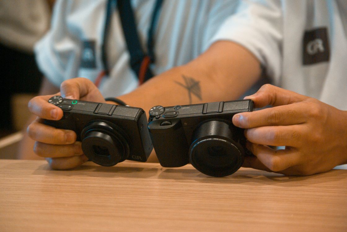 Close-up of Hands Holding Two Compact Cameras · Free Stock Photo
