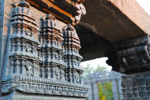 Detailed Indian temple carvings on stone pillars, showcasing ancient architectural art.