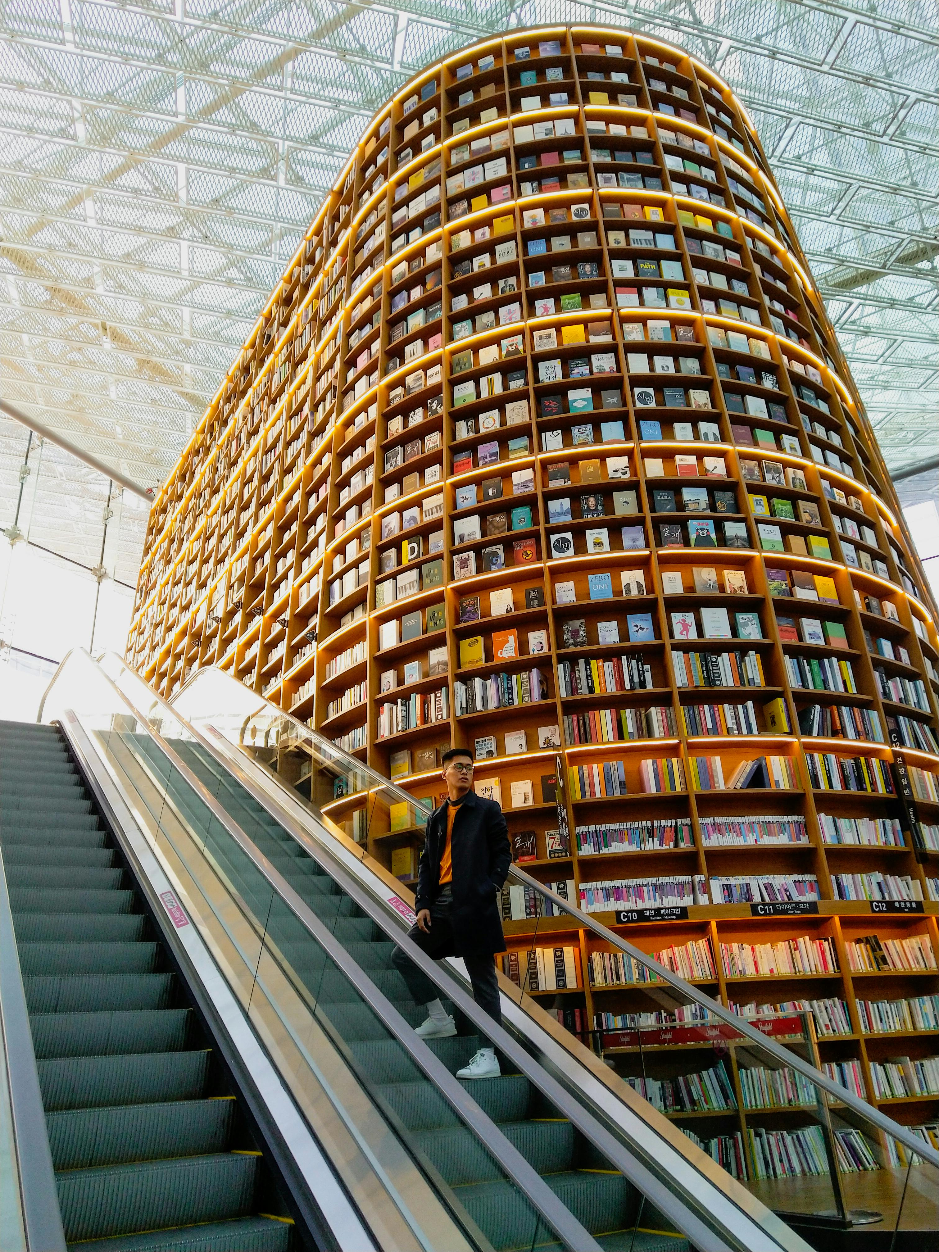 未来派图书馆内部，高耸的书架和玻璃天花板下的自动扶梯引人注目