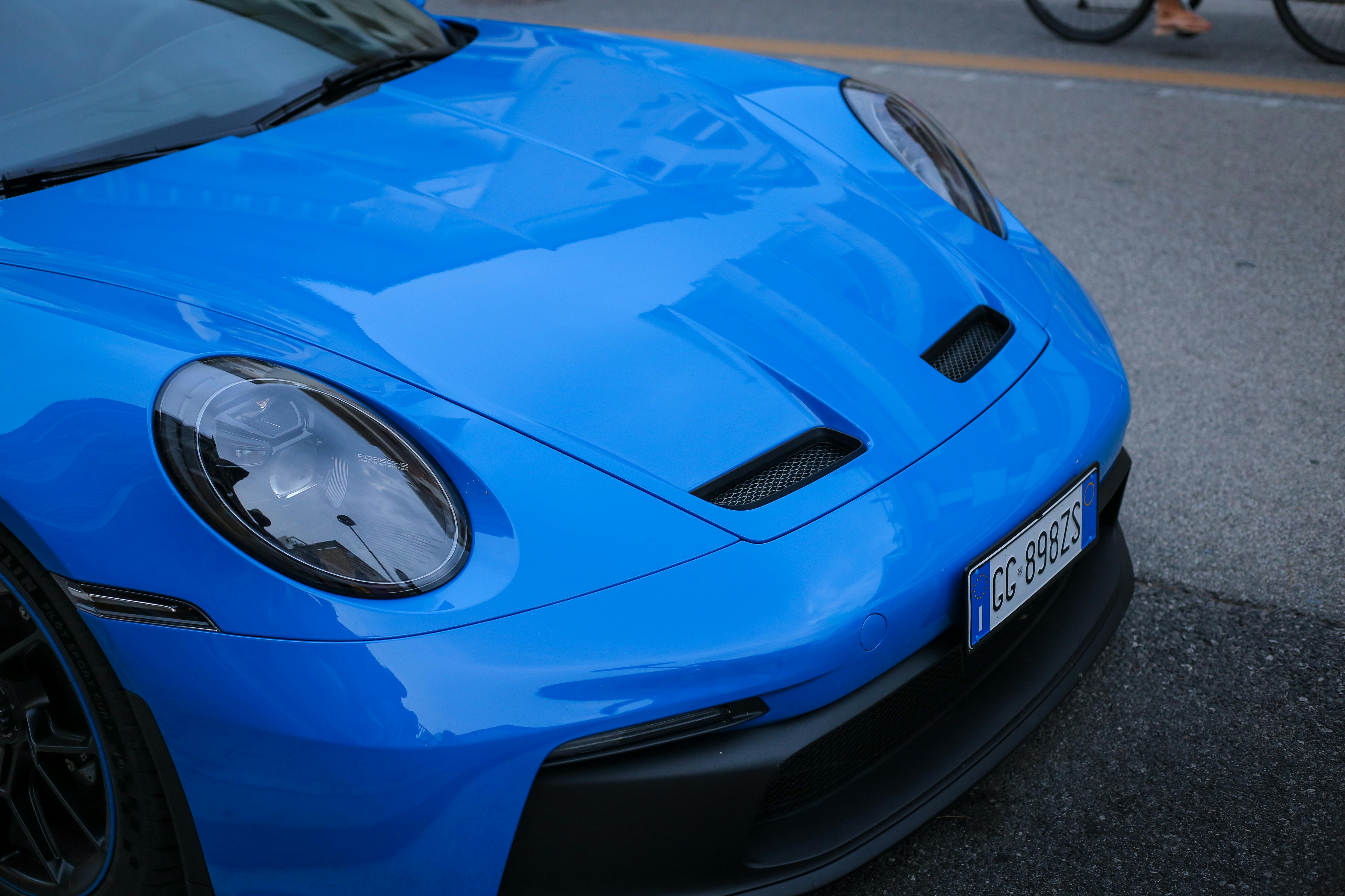Vibrant blue sports car parked on a street showcasing sleek front design and luxury appeal.