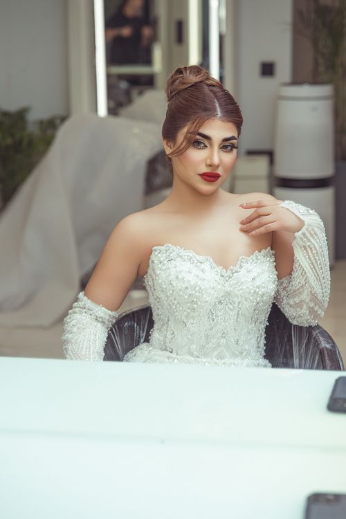 Free Elegant bride in white gown, posing indoors with a graceful and confident demeanor. Stock Photo