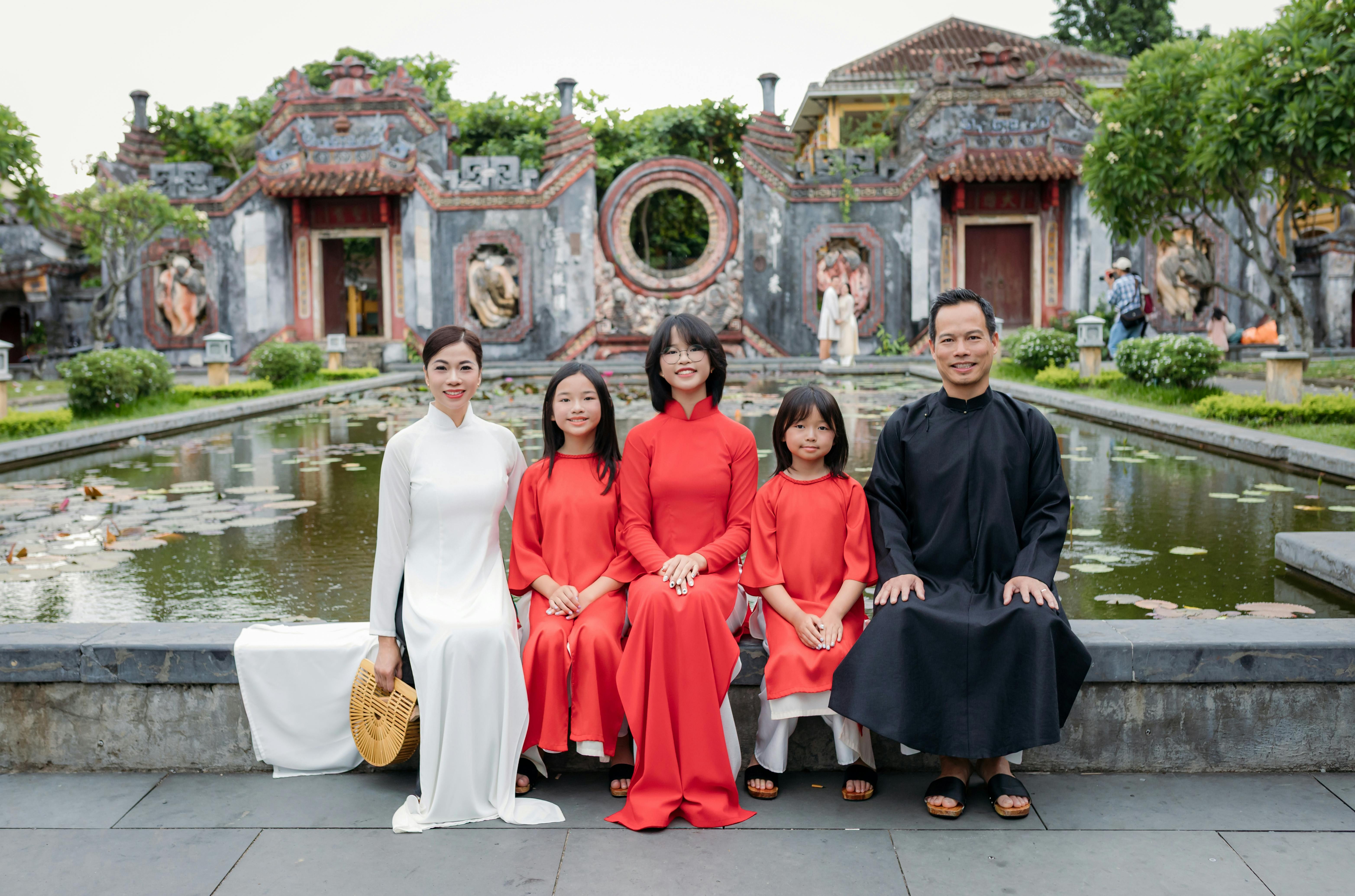 Family wearing traditional Vietnamese attire in Hội An, showcasing architectural beauty.