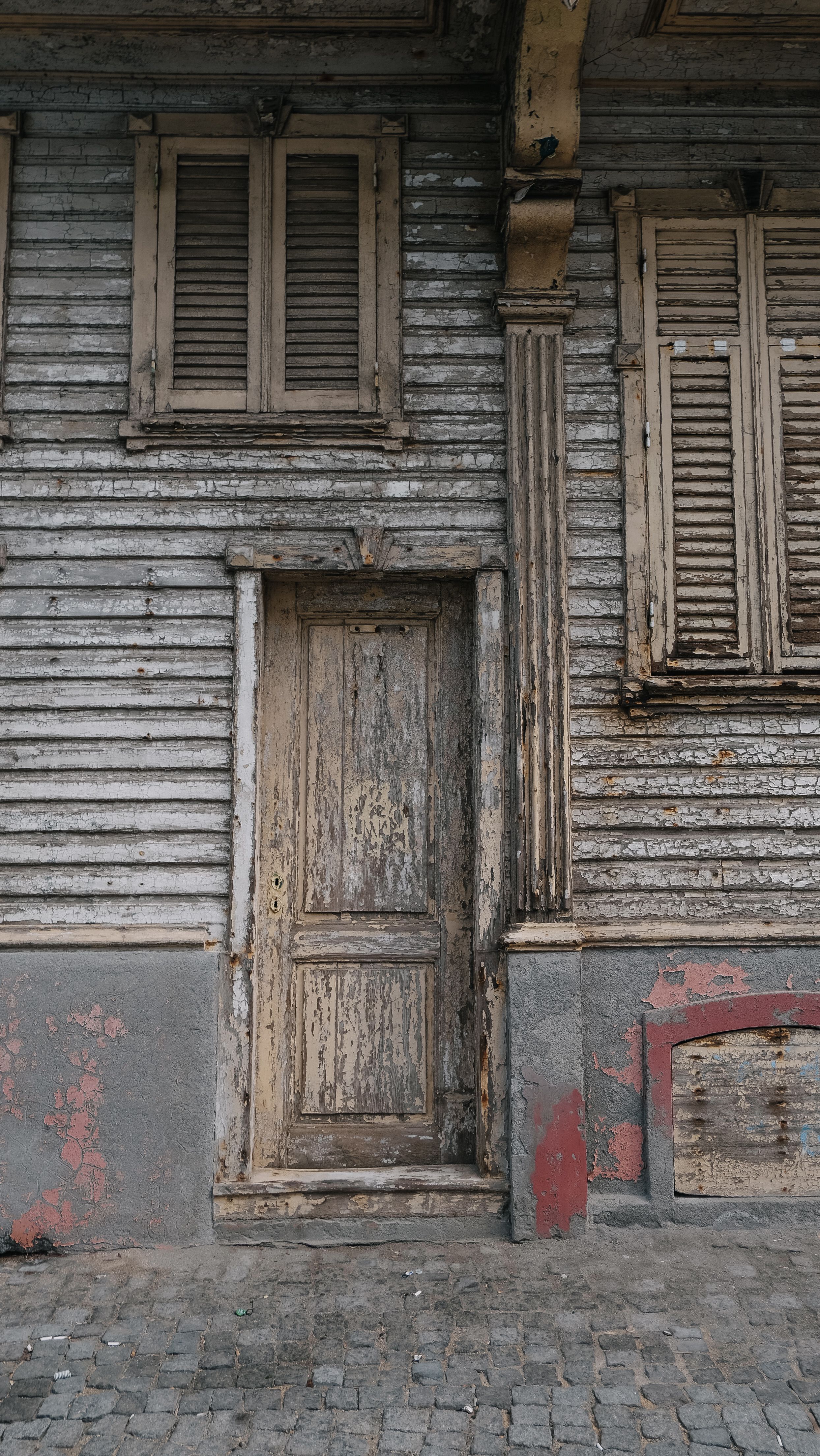 Weathered Wooden House Facade with Shuttered Windows · Free Stock Photo