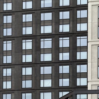 Close-up view of urban apartment building with dark and light facade featuring symmetrical windows.