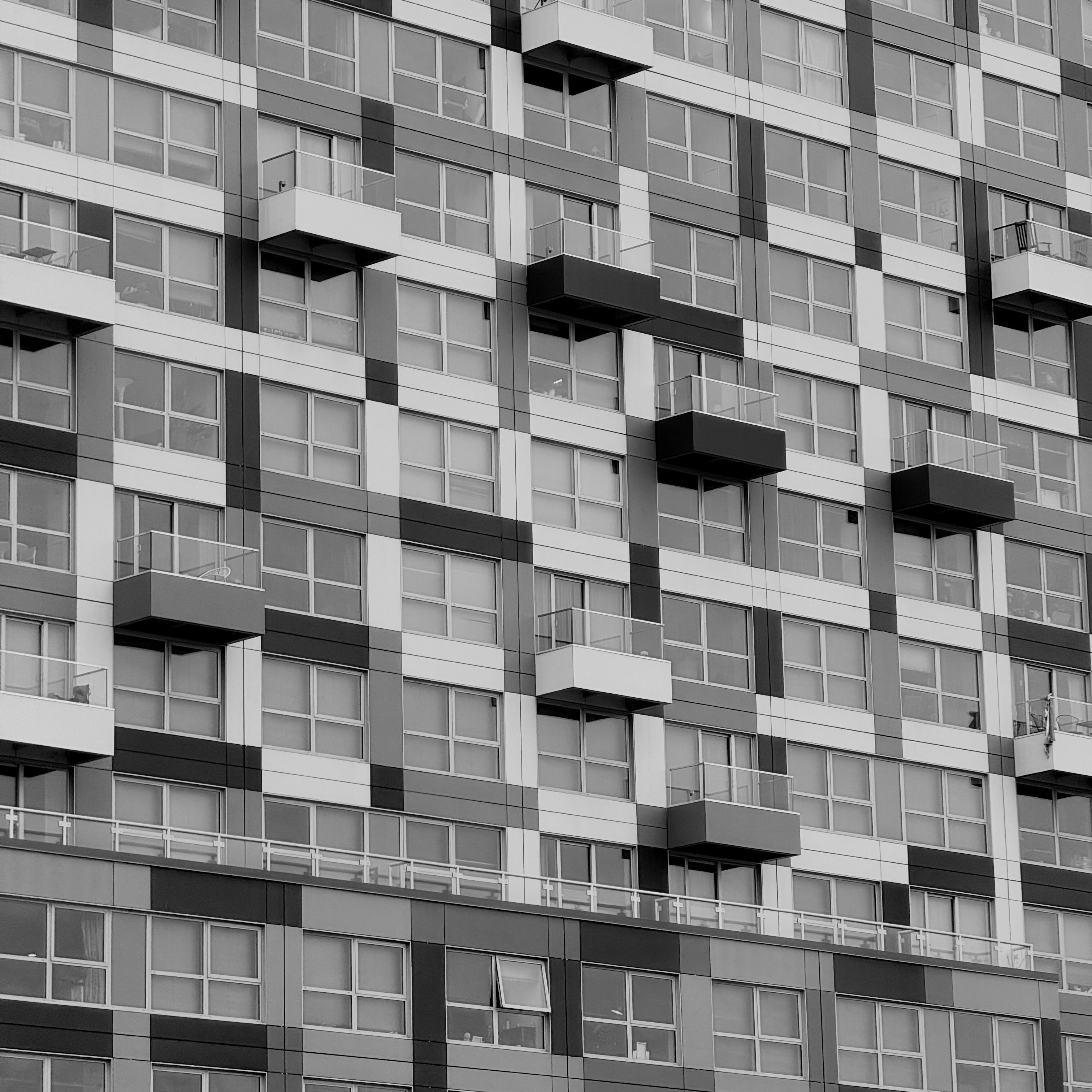 Black and white photo showcasing geometric facade of a modern apartment building.