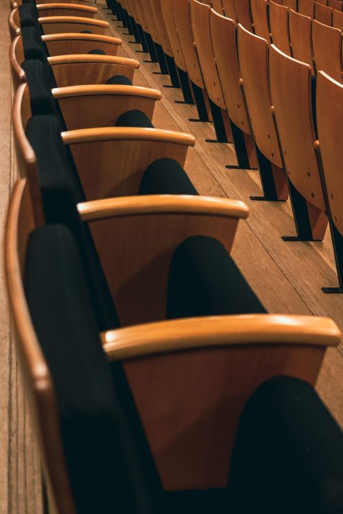 Free Close-up of empty wooden chairs in a São Paulo theater. Elegant and inviting setting. Stock Photo