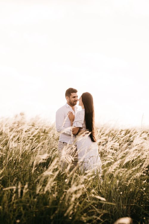 Free A young couple embraces in a sunlit meadow, capturing a moment of love and happiness. Stock Photo