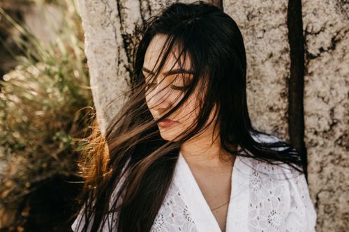 Free Serene outdoor portrait of a woman with long, flowing hair captured in natural light. Stock Photo