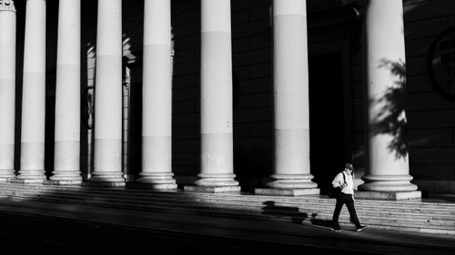 Free A solitary figure walks past grand columns in Buenos Aires, Argentina. Stock Photo