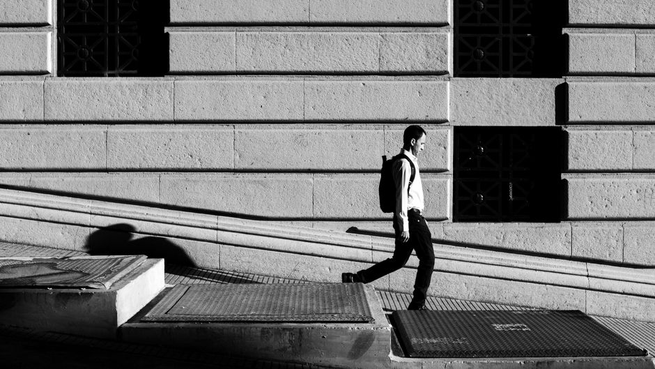 Un hombre solitario camina por una calle soleada en Buenos Aires, Argentina.