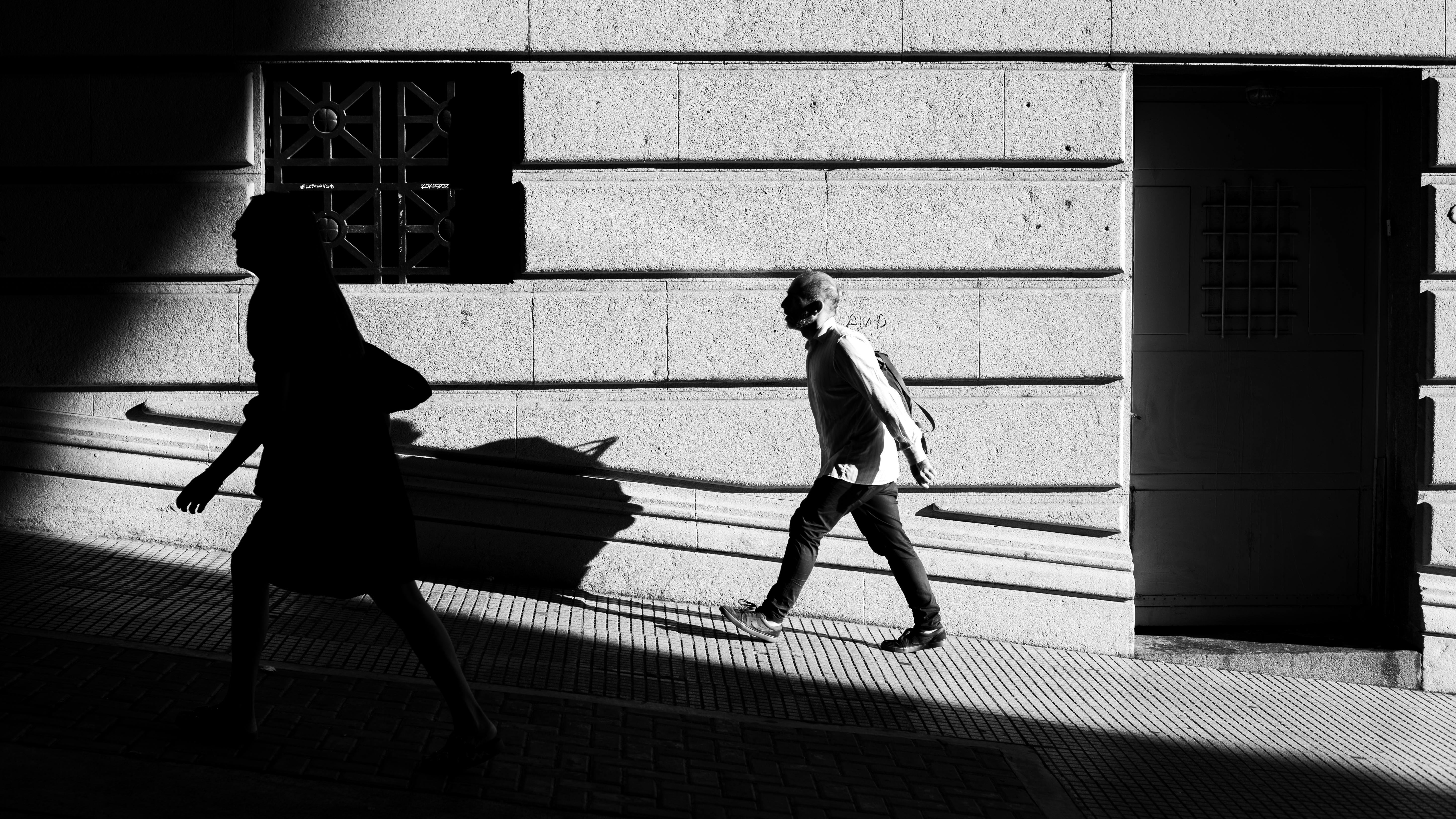 Free Silhouetted pedestrians on a sunny Buenos Aires street create dramatic shadows. Stock Photo