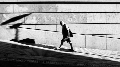 Free Dramatic black and white street photo capturing a lone man walking in Buenos Aires. Stock Photo