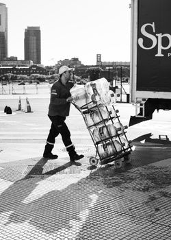 Black and white photo of a delivery worker with trolley on the streets of Buenos Aires, Argentina.