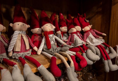 Free Festive Christmas elves in red and gray on wooden shelves, perfect holiday decor. Stock Photo