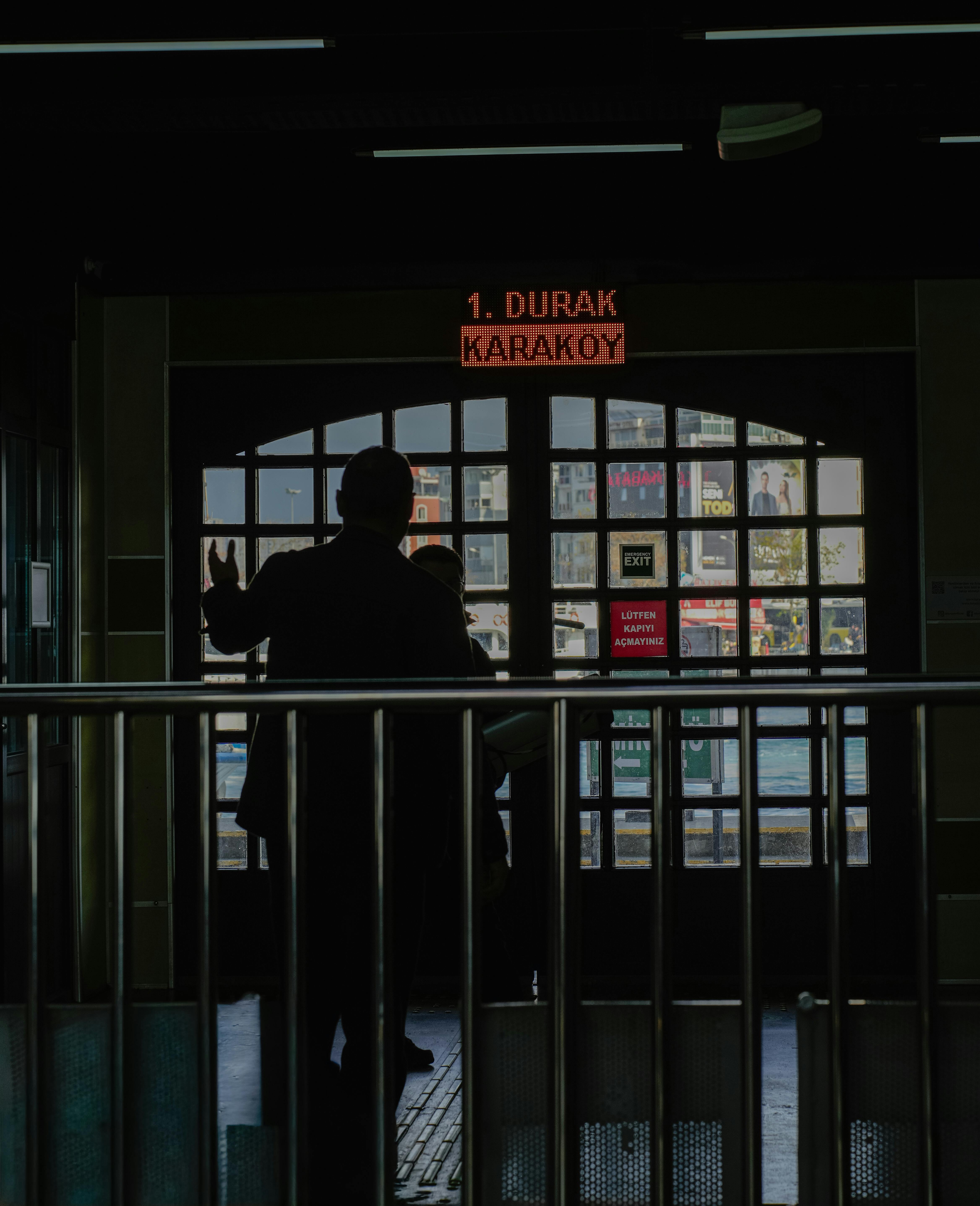 Ücretsiz İstanbul'daki Karaköy durağında silüet halinde görünen insanlar, şehir manzarasına gizem ve merak katıyor. Stok Fotoğraflar