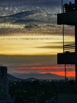 Stunning sunset view over Santiago's skyline with dramatic clouds and colorful horizon.