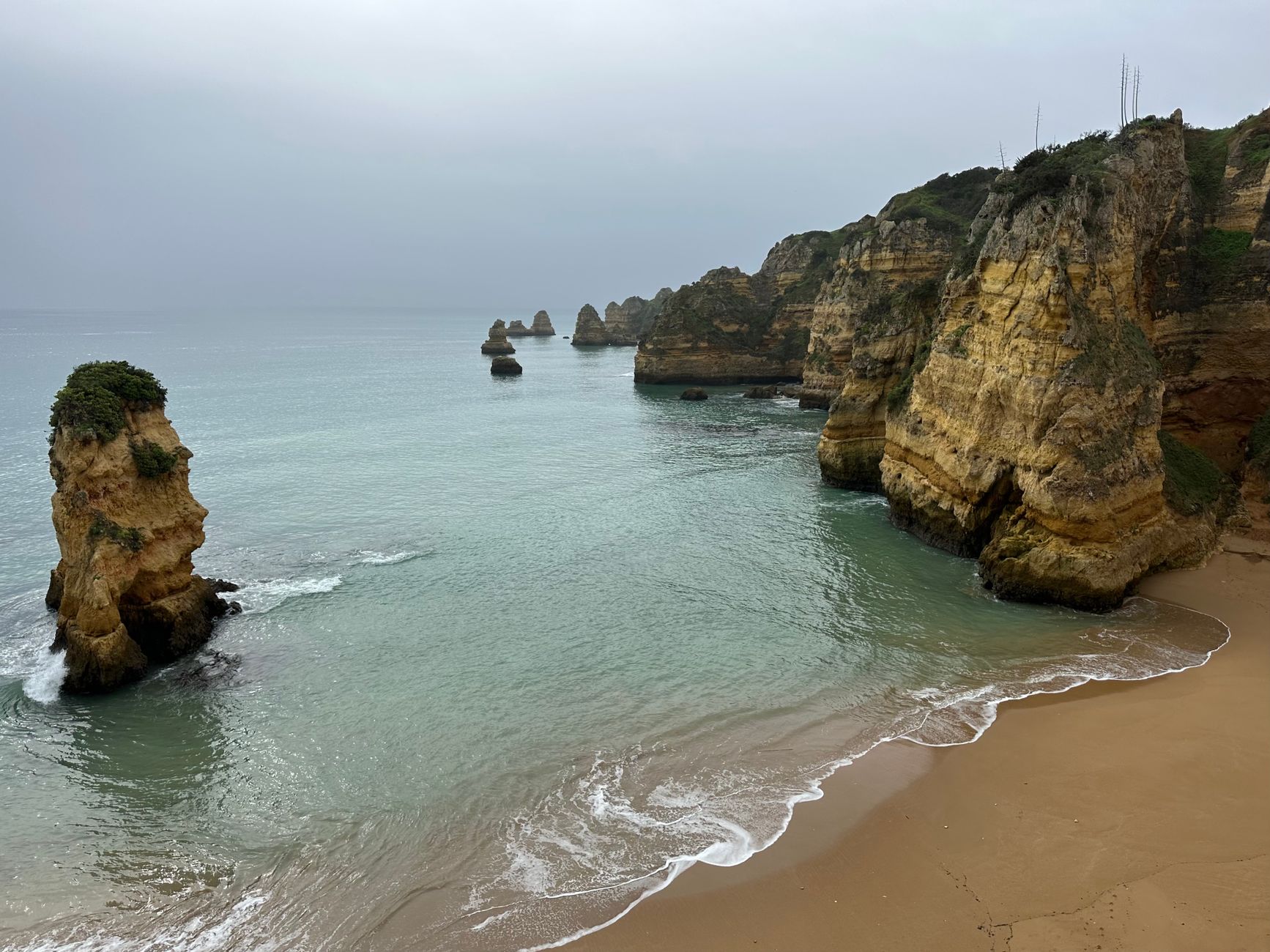 Stunning view of rugged cliffs and sea stacks along the Lagos coastline in Portugal.