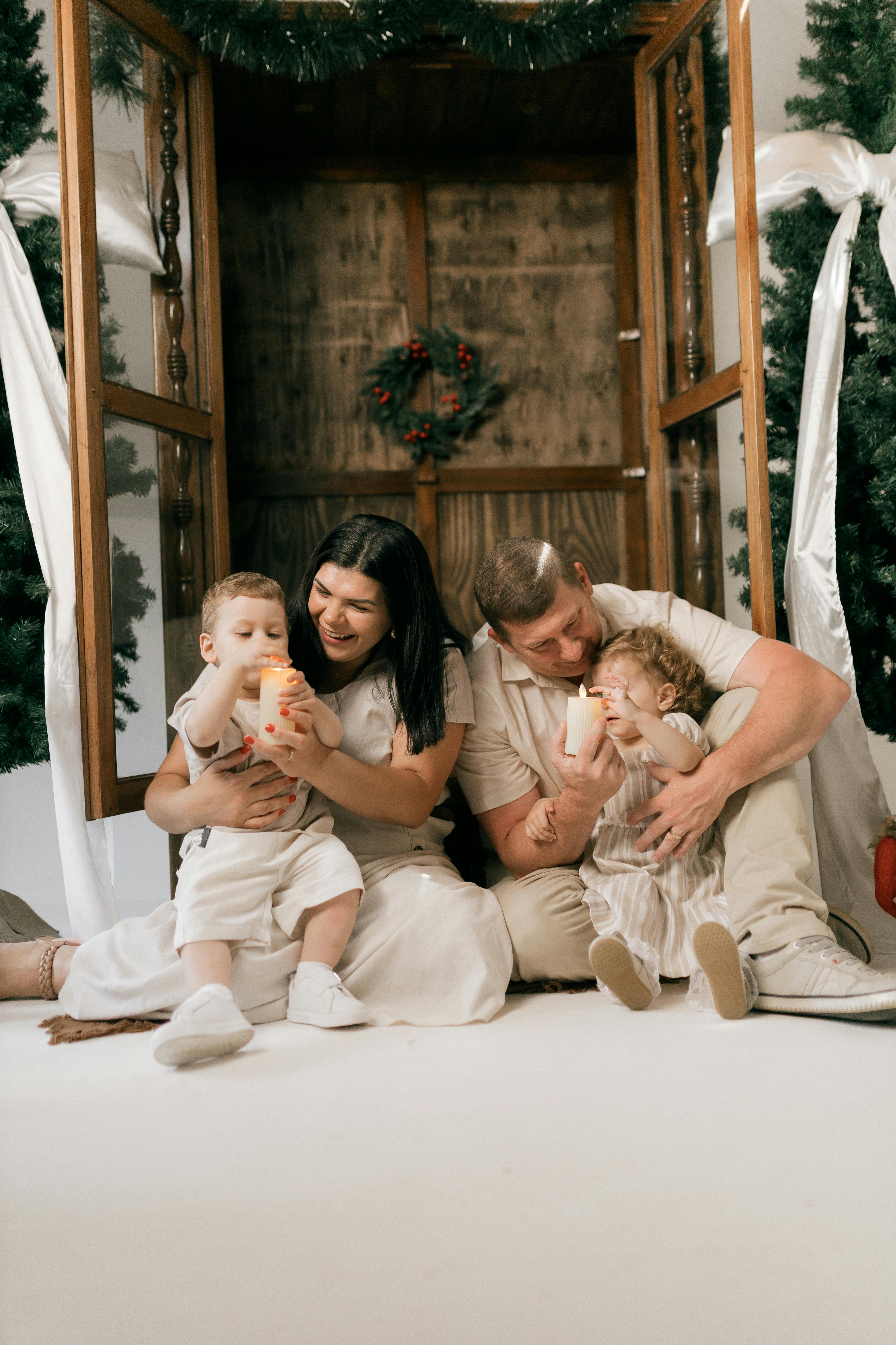 De franc Una família gaudint d'un càlid moment nadalenc a l'interior amb espelmes. Foto d'estoc