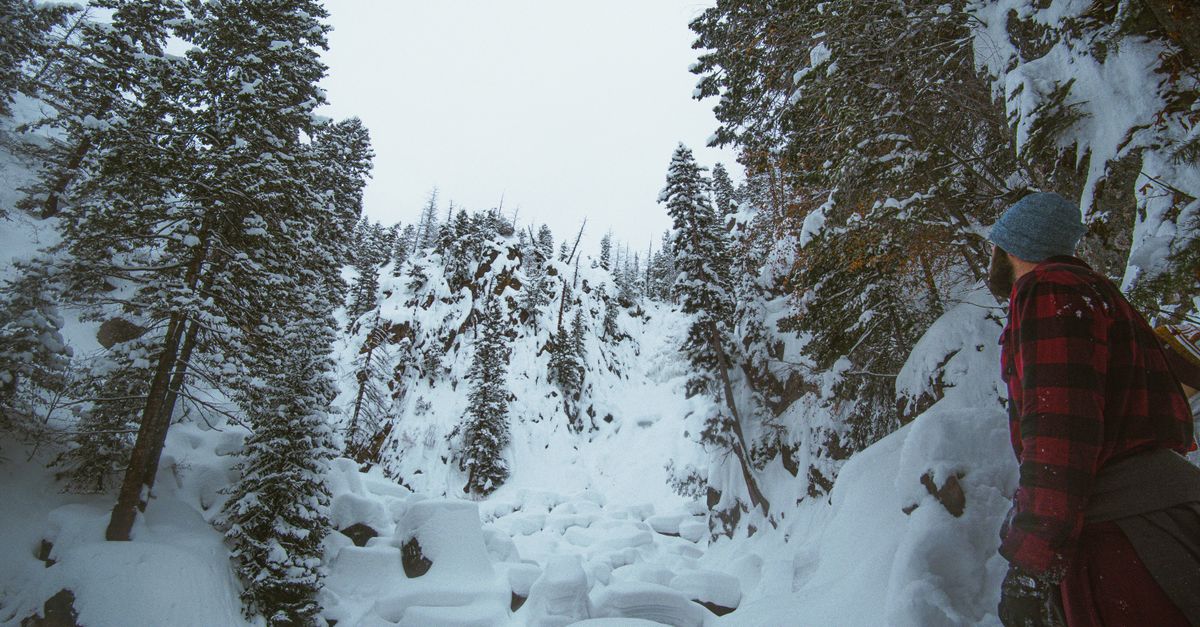 Man hiking through snowy landscape in Steamboat Springs, CO, surrounded by frosty trees.
