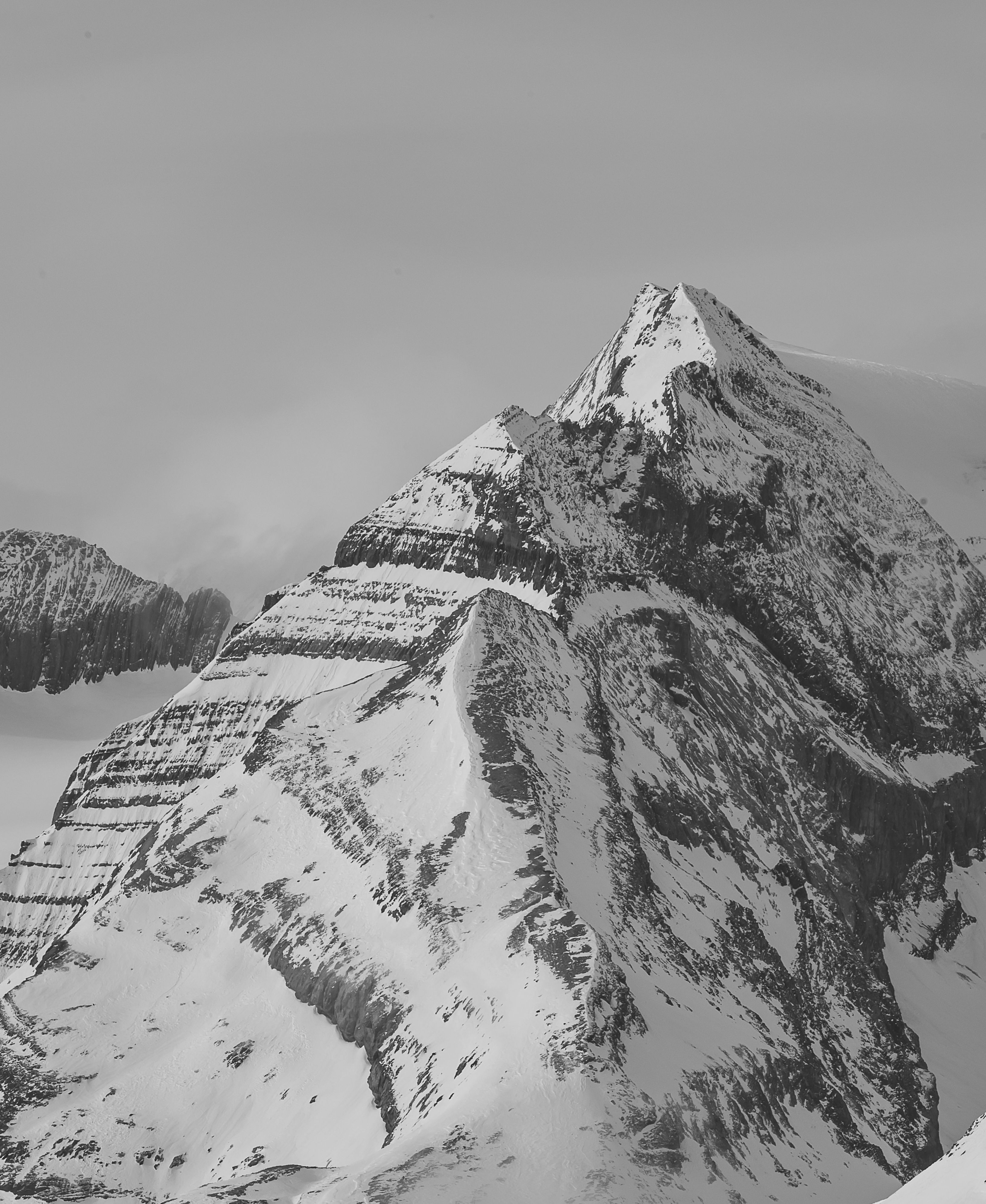 A dramatic black and white photograph of a snow-covered alpine mountain peak in Glarus Süd, Switzerland.