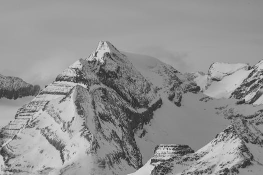 Dramatic black and white photo of snow-covered Alpine peaks in Switzerland's winter wilderness.