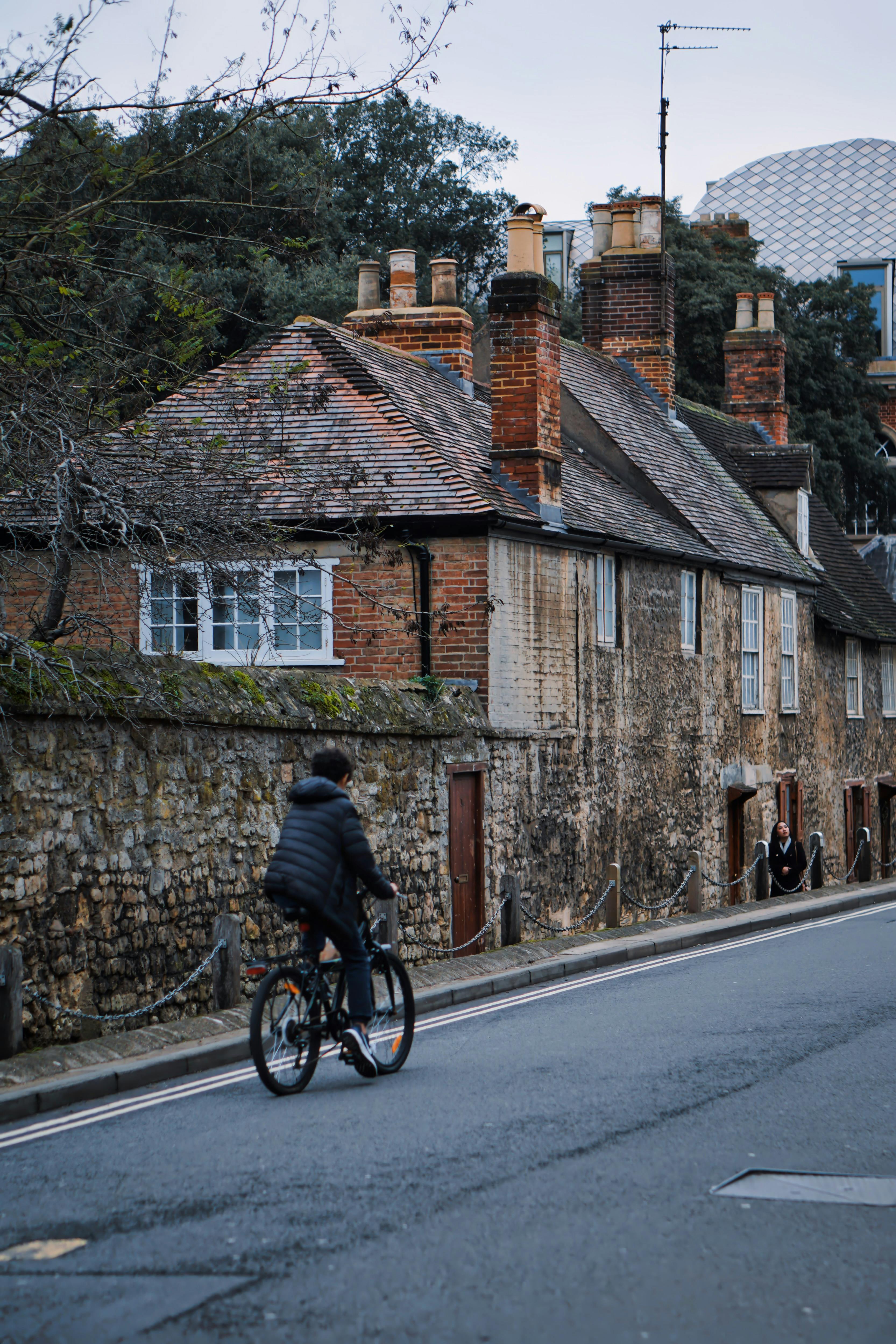 Cyclist Passing Historic Village Homes