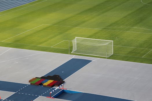 Aerial view of a soccer field with a goalpost and track, highlighting geometric patterns.