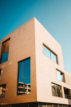 A striking building with geometric design against a clear blue sky, highlighting modern architecture.