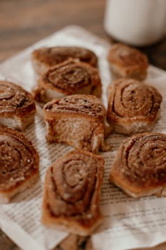 Close-up image of delicious cinnamon rolls on paper, perfect for breakfast or a sweet treat.